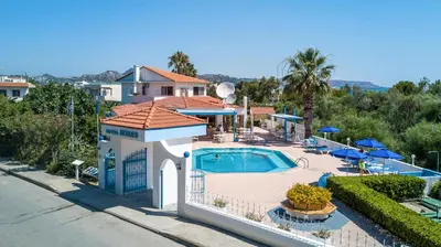 a house with a swimming pool in front of a house at Muses Hotel in Faliraki