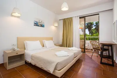 a hotel room with a bed and a balcony at Muses Hotel in Faliraki