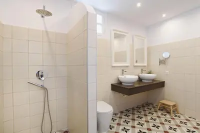 a bathroom with two sinks and a shower at Thea Villas and Suite in Líndos