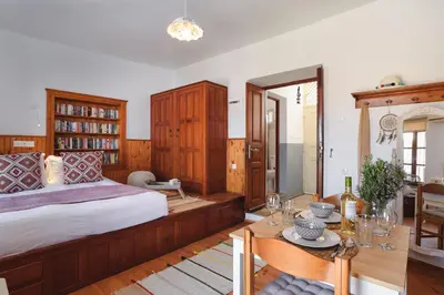 a bedroom with a bed and a table with glasses on it at Thea Villas and Suite in Líndos