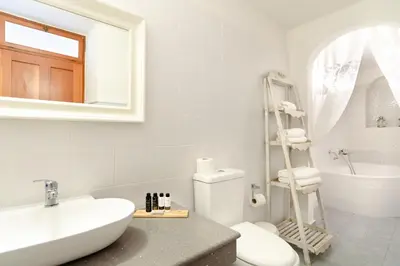 a white bathroom with a sink and a toilet at Thea Villas and Suite in Líndos