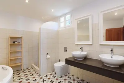 a bathroom with two sinks and a toilet at Thea Villas and Suite in Líndos
