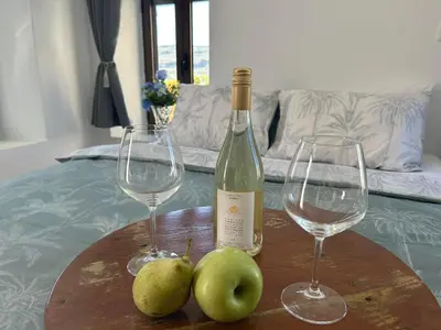 two glasses of wine and two apples on a table at New Lindos Studio 45 renovated in Líndos