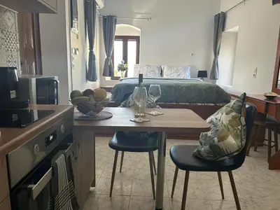 a room with a bed and a table and chairs at New Lindos Studio 45 renovated in Líndos