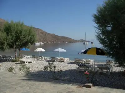a group of tables and umbrellas on a beach at Kleopatra's Rooms in Livadia