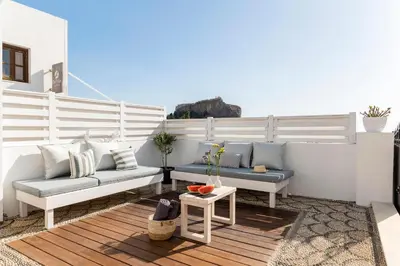 a patio with two couches and a table at Traditional Lindian Suites in Líndos
