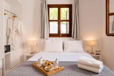 a bedroom with a bed with a tray of food on it at Traditional Lindian Suites in Líndos