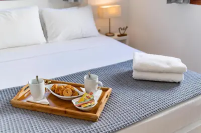 a tray with a tray of food on a bed at Traditional Lindian Suites in Líndos