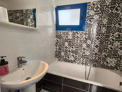 a bathroom with a tub and a sink and a window at Riva Del Mare in Archangelos