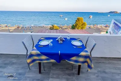 a blue table with chairs and a view of a beach at Riva Del Mare in Archangelos