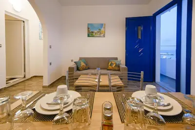 a dining room with a table and a couch at Riva Del Mare in Archangelos