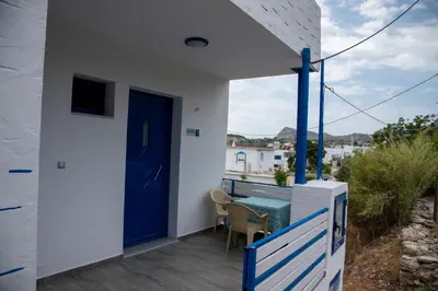 a blue door on a balcony with a table and chairs at Riva Del Mare in Archangelos