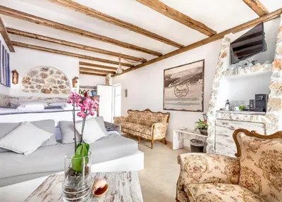a room with a bed and a table with flowers on it at Limeri Traditional Guest House in Monólithos