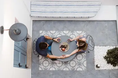 two people sitting at a table with a doughnut at Blue Jasmine Suites in Rhodes Town