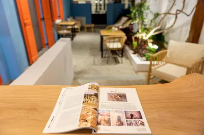 a magazine sitting on top of a wooden table at Blue Jasmine Suites in Rhodes Town