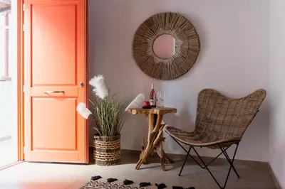 a room with a chair and a mirror and a table at Blue Jasmine Suites in Rhodes Town