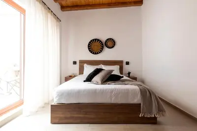 a bedroom with a bed and a clock on the wall at Blue Jasmine Suites in Rhodes Town