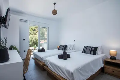 two beds in a room with white walls at Villa Tranquila Rhodes in Psinthos