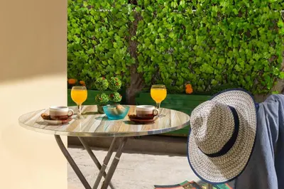 a table with two glasses of wine and a hat at Olivia's Sweet Home in Rhodes Town