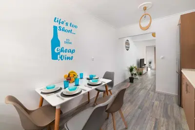 a kitchen and dining room with a white table and chairs at Olivia's Sweet Home in Rhodes Town