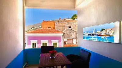 a table in a room with a view of a building at Captain's Suites in Symi