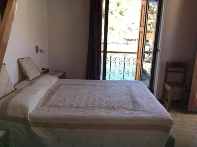 a bedroom with a large bed with a balcony at Captain's Suites in Symi