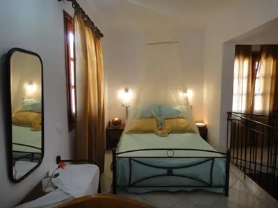 a bedroom with a bed with a mosquito net at Captain's Suites in Symi