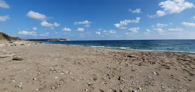 a sandy beach with rocks and the ocean at Villa Fantasea in Plimmiri