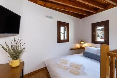 a bedroom with a bed and a flat screen tv at Lindos Vista Luxury Villa in Líndos