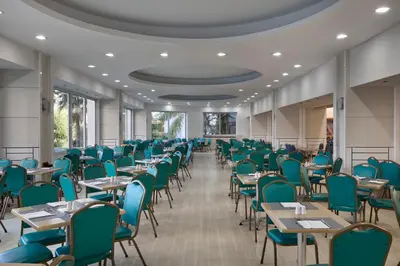 an empty dining room with tables and chairs at Esperides Beach Resort in Faliraki
