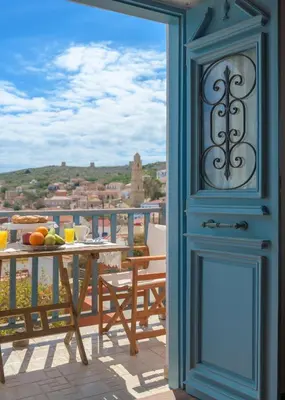 a blue door leading to a balcony with a table at Villa Katingo in Halki
