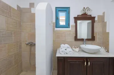 a bathroom with a sink and a mirror and a shower at Villa Katingo in Halki