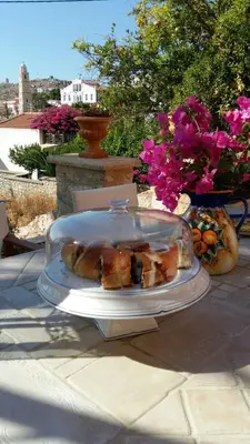 a plate of food on a table with flowers at Villa Katingo in Halki