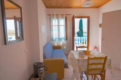 a living room with a blue couch and a table at Filoxenia Apartments in Halki