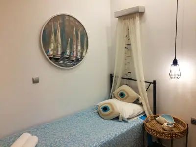 a bedroom with a bed with a swing and a mirror at Kima Stegna sea view in Archangelos