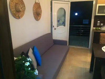 a living room with a couch in a room with a door at Kima Stegna sea view in Archangelos
