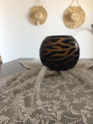 a black vase sitting on top of a bed at Kima Stegna sea view in Archangelos