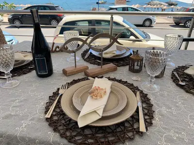 a table with a plate of food and a bottle of wine at Kima Stegna sea view in Archangelos