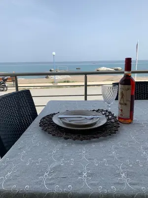 a table with a plate and a bottle of wine at Kima Stegna sea view in Archangelos