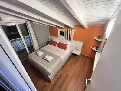 a bedroom with a bed with orange walls at Colorful House (Attic) in Kremasti