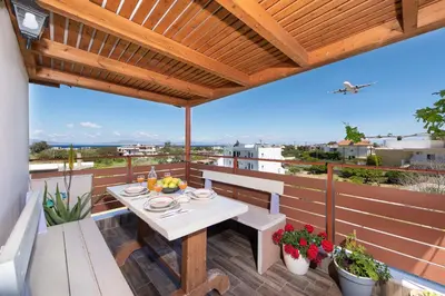 a patio with a table and benches on a balcony at Colorful House (Attic) in Kremasti