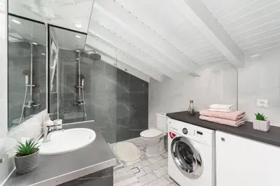 a bathroom with a washing machine and a sink at Colorful House (Attic) in Kremasti