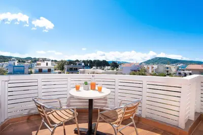 a table and chairs on a balcony with a view at Colorful House (Attic) in Kremasti