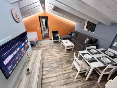 a living room with a table and a couch at Colorful House (Attic) in Kremasti