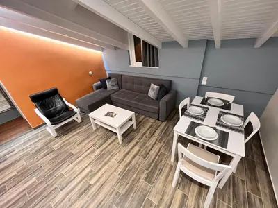 a living room with a couch and a table and chairs at Colorful House (Attic) in Kremasti