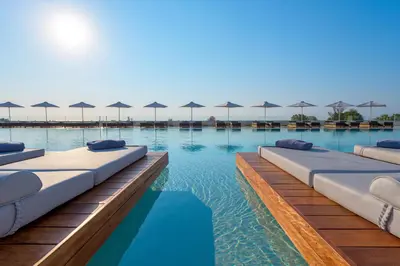 a swimming pool with lounge chairs and umbrellas at Gennadi Grand Resort - Premium All Inclusive in Gennadi