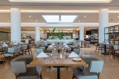 a restaurant with tables and chairs in a building at Gennadi Grand Resort - Premium All Inclusive in Gennadi