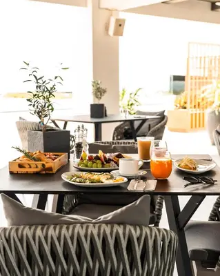 a table with plates of food and orange juice at Gennadi Grand Resort - Premium All Inclusive in Gennadi
