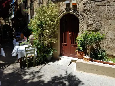 a wooden door to a building with a table and chairs at Diasoulas house in Rhodes Town