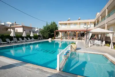 a large swimming pool in front of a hotel at Barbie Hotel Apartments in Ialyssos